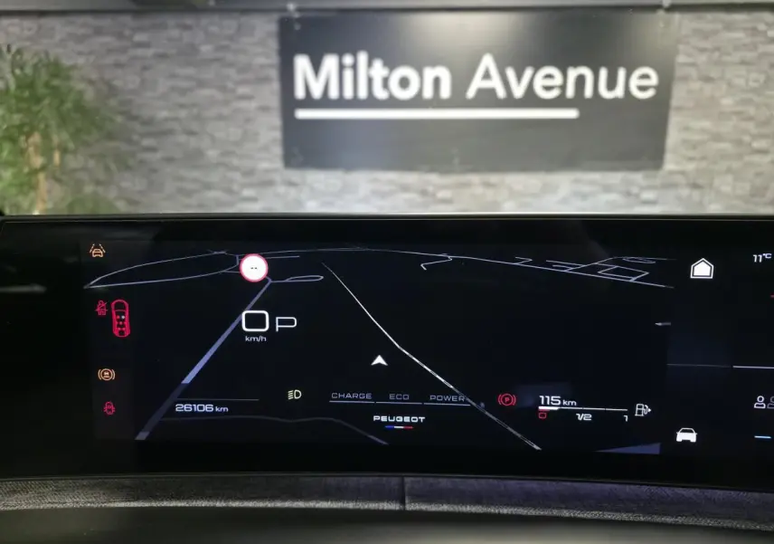 Affichage numérique du tableau de bord du Peugeot 5008 gris, vue frontale centrée sur l'écran de navigation et informations de conduite.