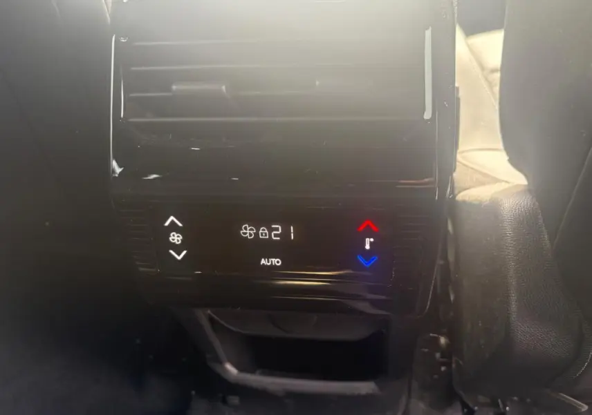 Détail de la commande de climatisation arrière digitale du Peugeot 5008 Hybrid noir, affichant 21°C en mode automatique.