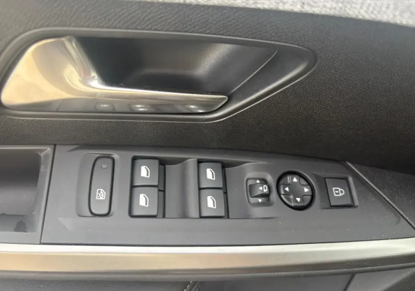 Détail des commandes de porte côté gauche du Peugeot 5008 Hybrid 2025 en noir, avec boutons de vitres et rétroviseurs.
