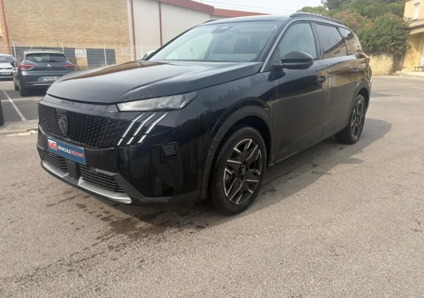 Peugeot 5008 Hybrid noir vue 3/4 avant droit, calandre noire avec signature lumineuse verticale distinctive.