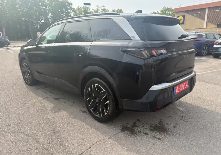 Peugeot 5008 Hybrid noir en 3/4 arrière droit, avec jantes alliage et feux arrière LED distinctifs.