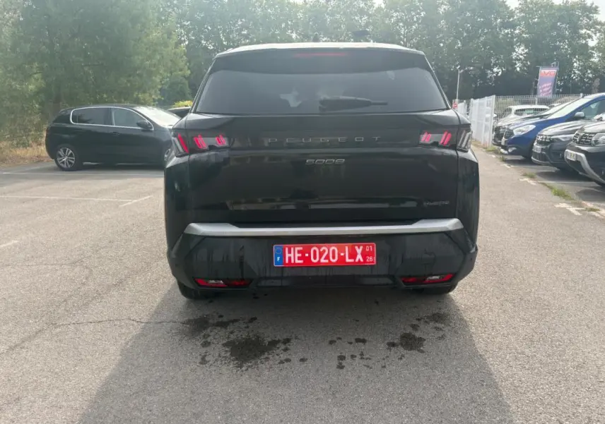 Vue arrière d'un Peugeot 5008 noir 2025 Hybrid 145 ch avec feux arrière distinctifs et plaque d'immatriculation rouge.