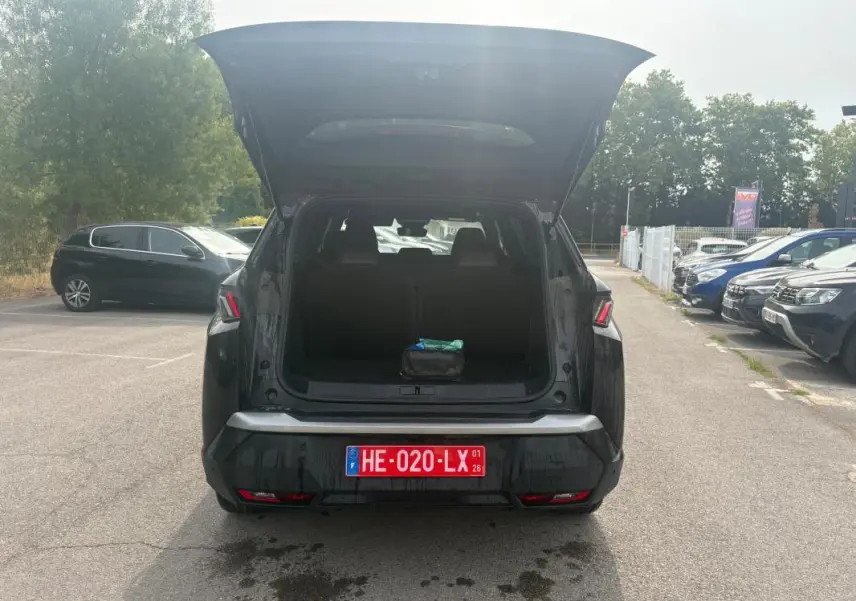 Vue arrière d’un Peugeot 5008 noir 2025 avec coffre ouvert et plaque d’immatriculation rouge visible en extérieur.