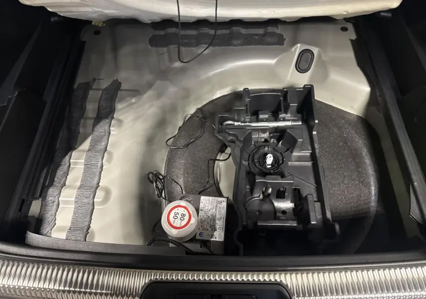 Coffre ouvert du DS7 Crossback gris montrant le rangement sous plancher avec kit de dépannage et compresseur.
