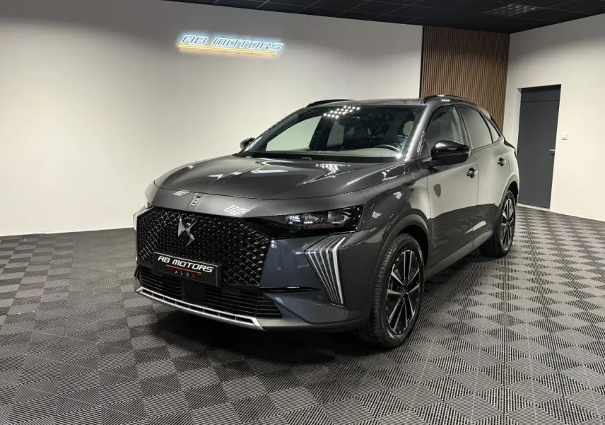 DS7 Crossback gris en 3/4 avant droit, avec calandre noire brillante et jantes alliage 19 pouces distinctives.