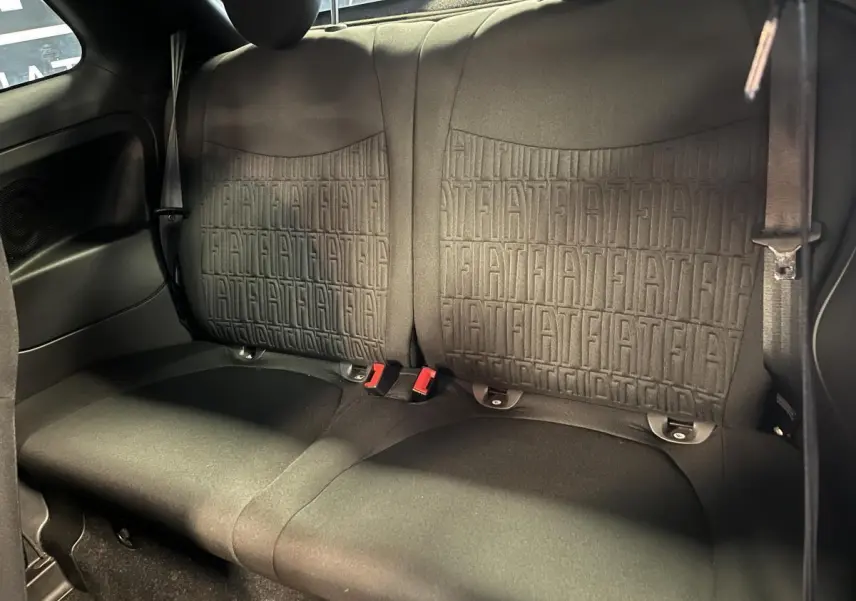 Banquette arrière noire de Fiat 500 2023 avec motifs FIAT embossés et ceintures de sécurité visibles.