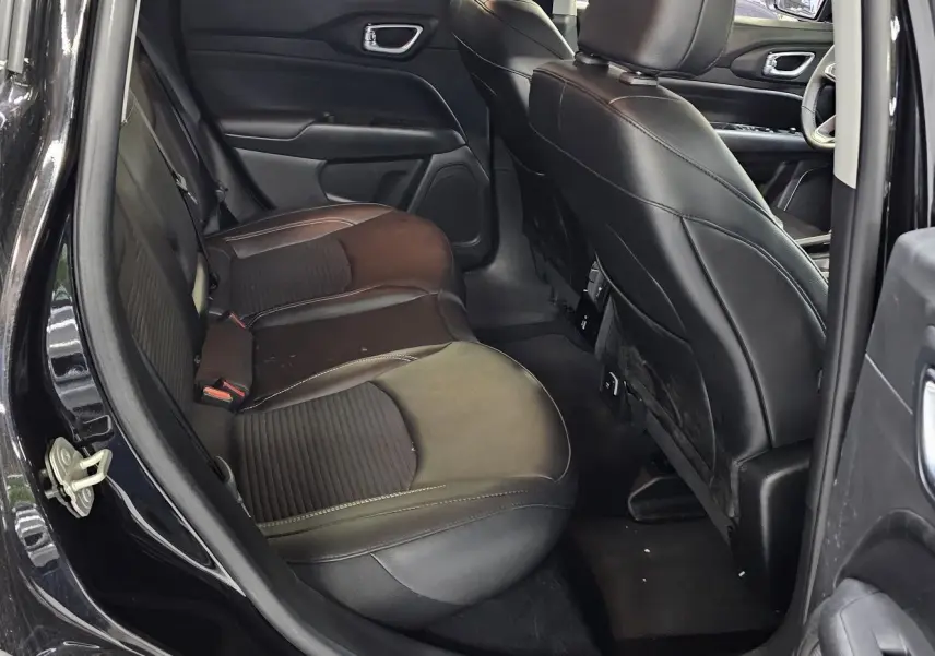 Vue intérieure côté droit sur les sièges arrière en cuir noir du Jeep Compass 2023 avec portières ouvertes.