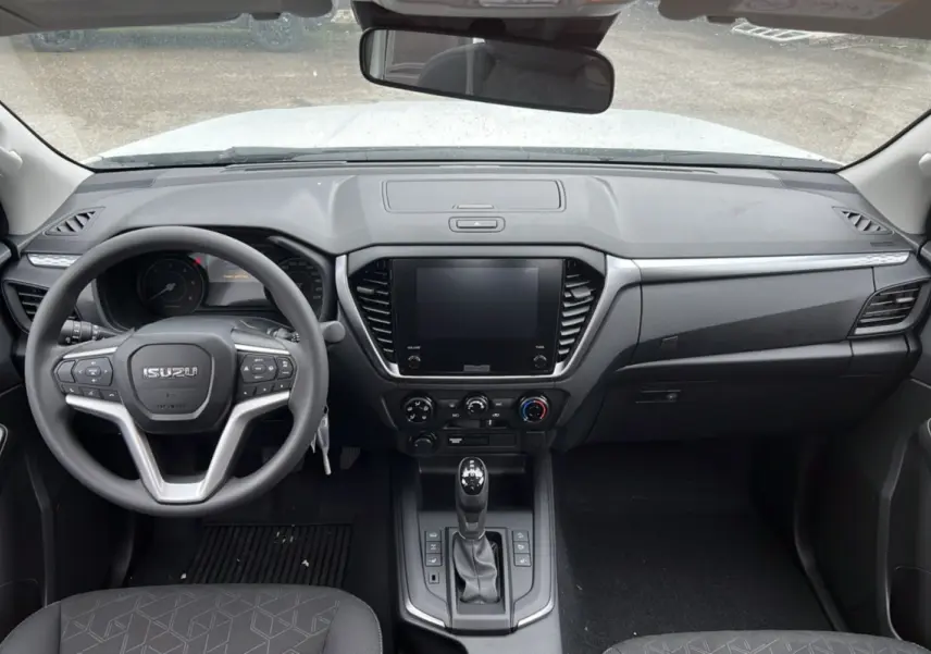 Vue intérieure frontale de l'Isuzu D-MAX 2026 Splash White avec tableau de bord moderne et volant multifonctions.