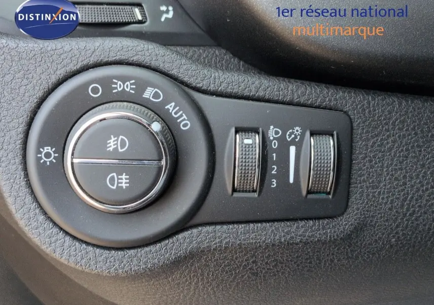 Gros plan sur les commandes d’éclairage et réglages du tableau de bord noir du Fiat 500X 2018.