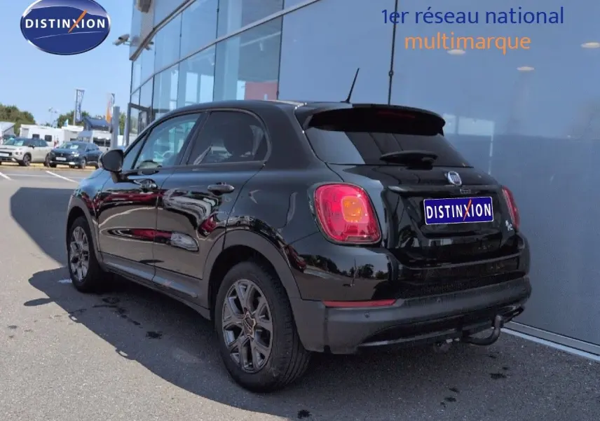 Vue 3/4 arrière droite d'une FIAT 500X noire Cinéma pastel avec jantes alu et becquet arrière.