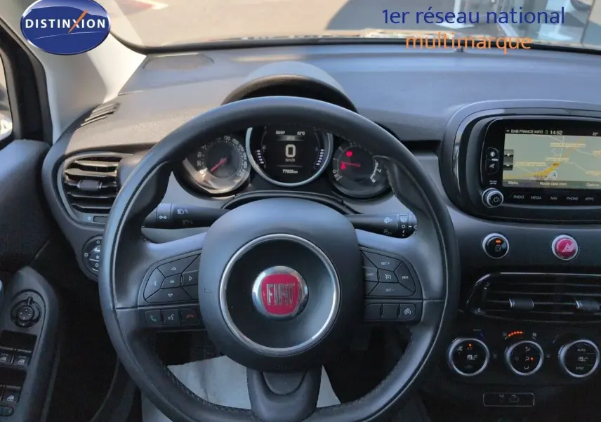 Vue intérieure centrée sur le volant cuir multifonction et le tableau de bord avec écran tactile du Fiat 500X noir.