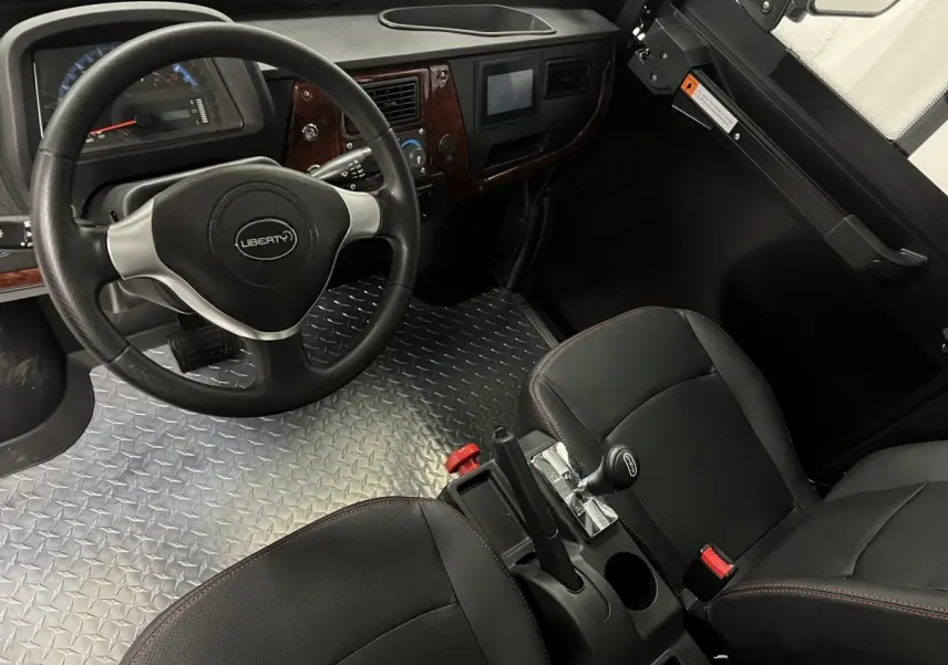 Intérieur vu côté conducteur du Liberty L7e H2 Cargo 2025, volant 3 branches, sol aluminium antidérapant et sièges noirs.