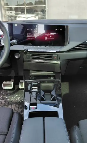 Vue intérieure de l’Opel Astra 2025 diesel noire, montrant la console centrale moderne avec écran tactile et commandes automatiques.