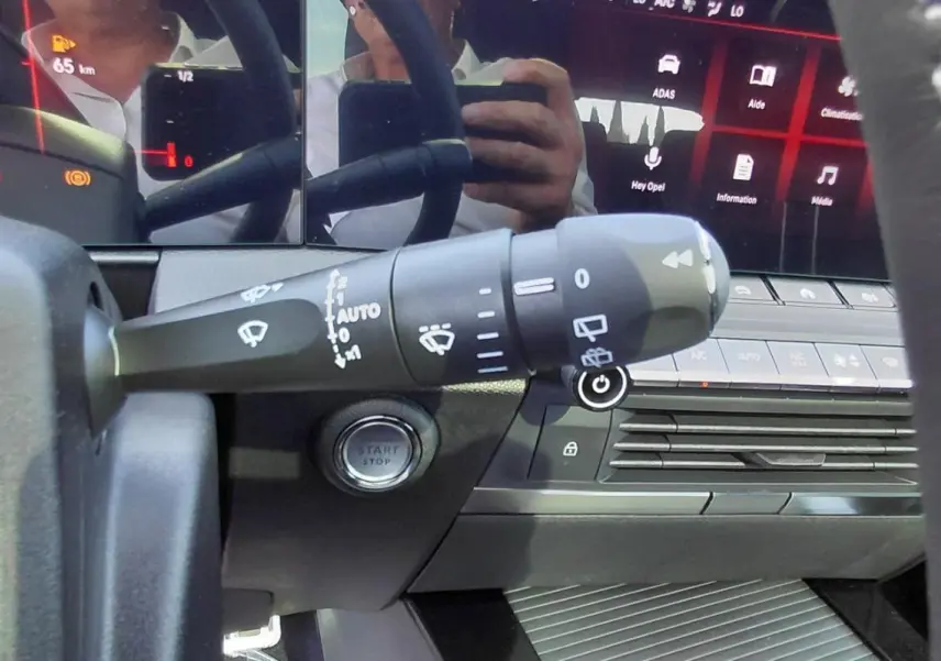 Gros plan sur la commande d’essuie-glace et le bouton start/stop de l’Opel Astra noire 2025, vue côté gauche du volant.