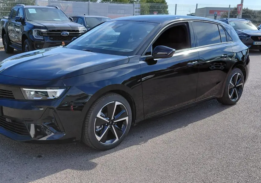 Opel Astra noire 2025 vue 3/4 avant droit, avec jantes alliage bicolores et vitres teintées.