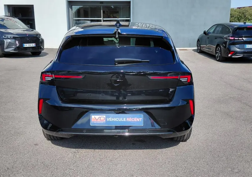 Vue arrière d'une Opel Astra noire 2025, avec feux arrière fins et plaque "Véhicule récent" visible.