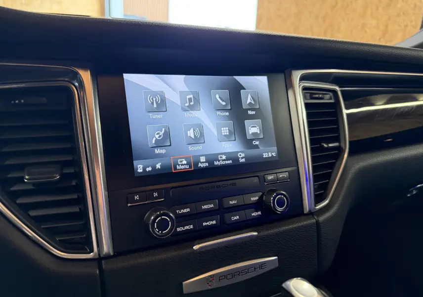 Vue rapprochée de la console centrale noire du Porsche Macan S avec écran tactile et commandes audio visibles.