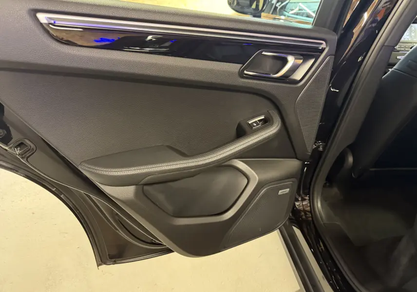 Vue intérieure de la porte arrière gauche noire du Porsche Macan S avec haut-parleur Bose et garnitures cuir.