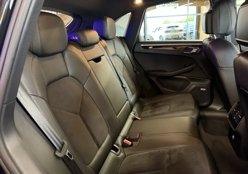 Vue intérieure côté droit des sièges arrière en cuir noir du Porsche Macan S 3.0i avec finitions élégantes et appuie-têtes réglables.