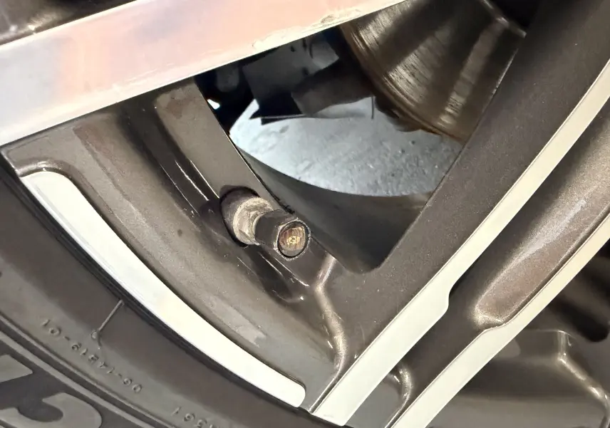 Gros plan sur la jante alu 21 pouces noire du Porsche Macan S 3.0i, mettant en valeur le détail du boulon de roue.
