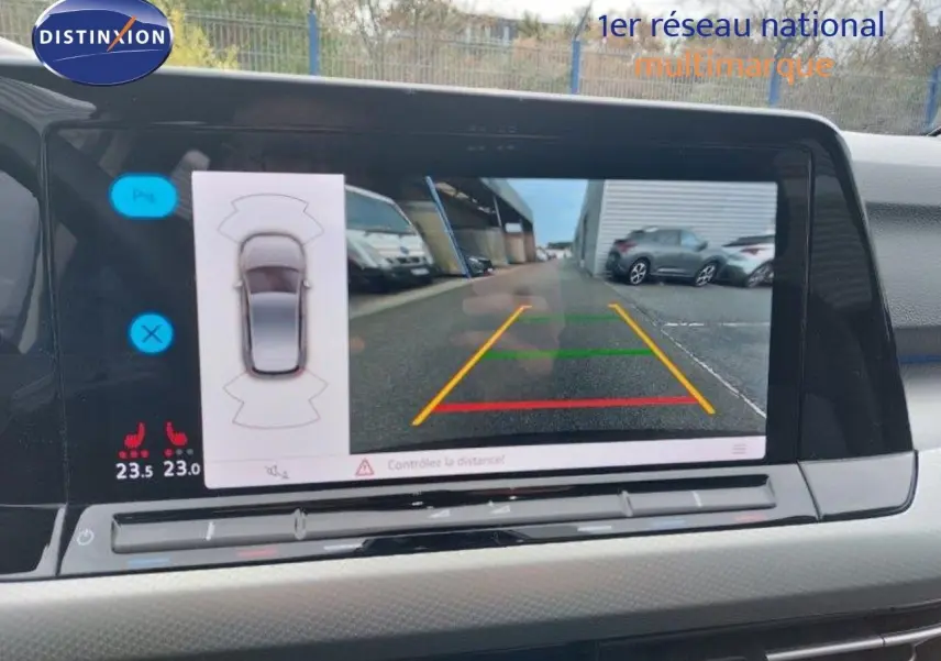Vue intérieure du tableau de bord de la Volkswagen Golf 2024, écran affichant la caméra de recul avec repères colorés.