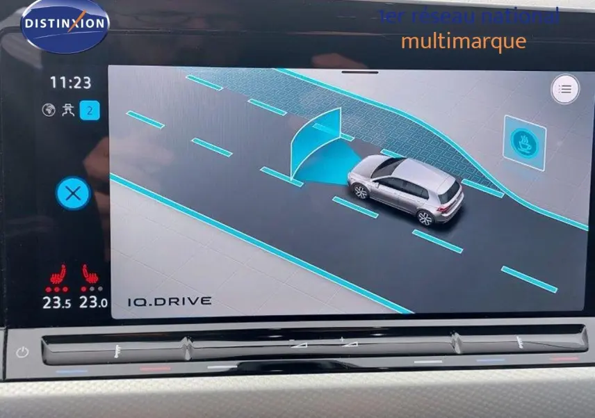 Écran intérieur montrant l'assistance à la conduite d'une Volkswagen Golf noire métal, vue de dessus en simulation.