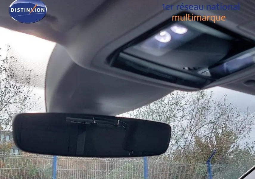Vue intérieure centrée sur le rétroviseur intérieur d'une Volkswagen Golf noire métal 2024 avec toit ouvrant partiel visible.