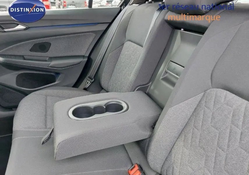 Vue intérieure côté droit des sièges arrière gris tissu avec accoudoir central rabattable et porte-gobelets de la Volkswagen Golf 1.5 TSI 2024.
