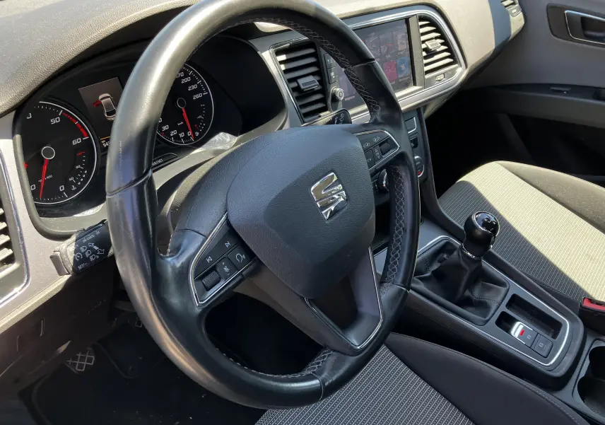 Vue intérieure côté conducteur du tableau de bord noir et volant cuir avec levier de vitesse manuel d'une SEAT Leon 2018.