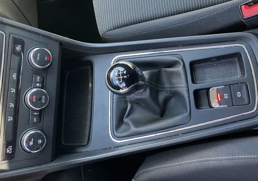 Vue rapprochée de la console centrale noire du SEAT LEON 1,6L TDI 115 STYLE 2018 avec levier de vitesse manuel et commandes climatiques.