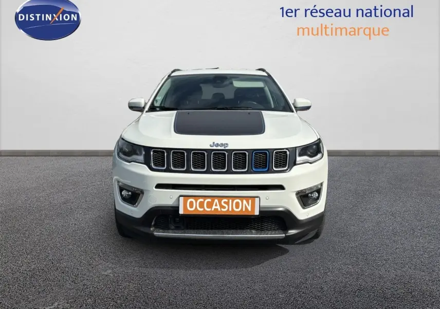 Vue frontale d'un Jeep Compass blanc avec capot noir et calandre caractéristique, en extérieur sur sol gris.