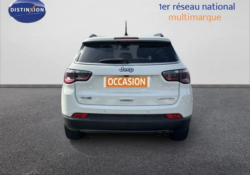 Vue arrière d'un Jeep Compass blanc hybride rechargeable avec badge Limited et double sortie d'échappement.