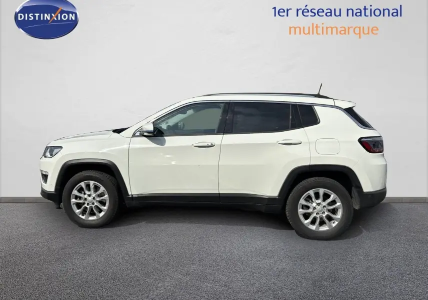 Profil côté gauche d'un Jeep Compass blanc 2021 hybride rechargeable avec jantes alliage et toit noir.