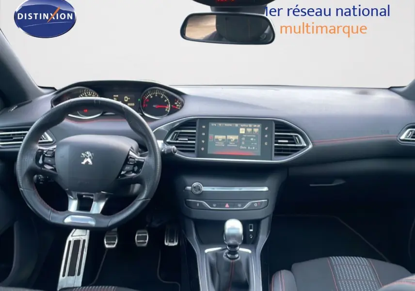 Vue intérieure avant de la Peugeot 308 GT Line 2017, tableau de bord noir avec volant sport et levier de vitesse manuel.
