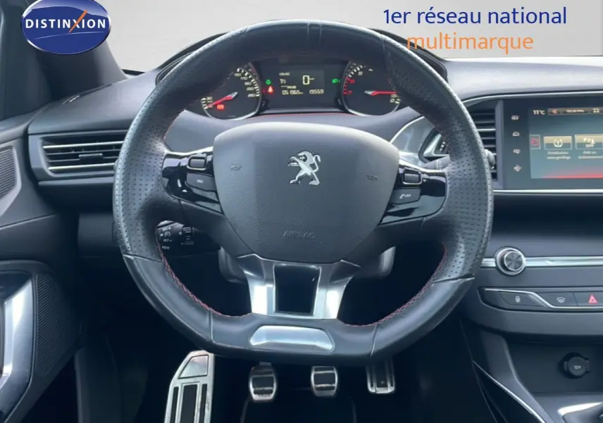 Vue intérieure centrée sur le volant en cuir perforé noir du Peugeot 308 GT Line 2017 avec tableau de bord et écran tactile.