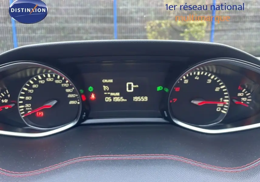 Vue rapprochée du tableau de bord de la Peugeot 308 gris Artense, affichant le compteur et l’ordinateur de bord allumés.