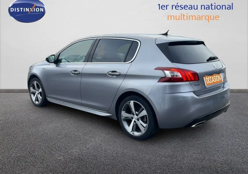 Vue 3/4 arrière droite d'une Peugeot 308 gris Artense avec jantes alliage et vitres teintées.