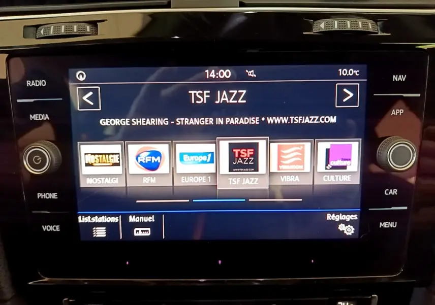 Écran tactile central affichant la radio TSF Jazz dans l'habitacle d'une Volkswagen Golf gris clair, vue de face.