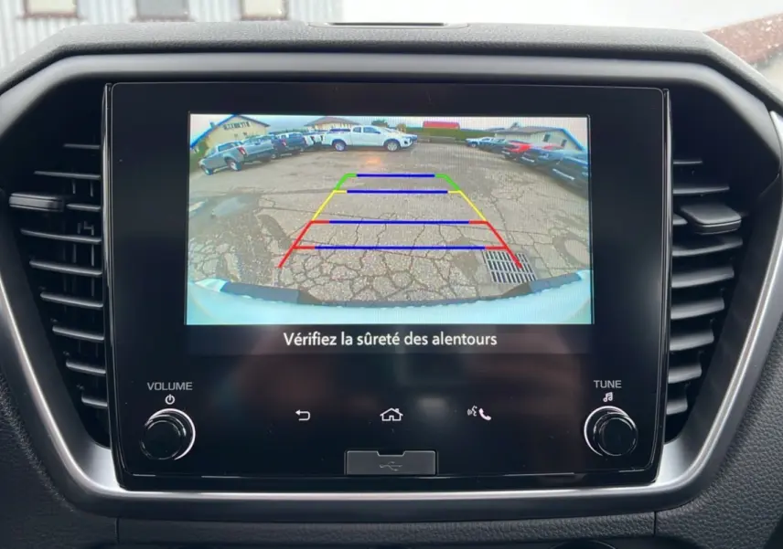 Écran central affichant la caméra de recul du pick-up Isuzu D-MAX blanc, avec lignes de guidage colorées.