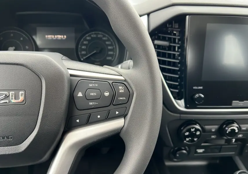 Vue rapprochée du volant multifonctions gris et de l’écran tactile du tableau de bord de l’Isuzu D-MAX 2026.