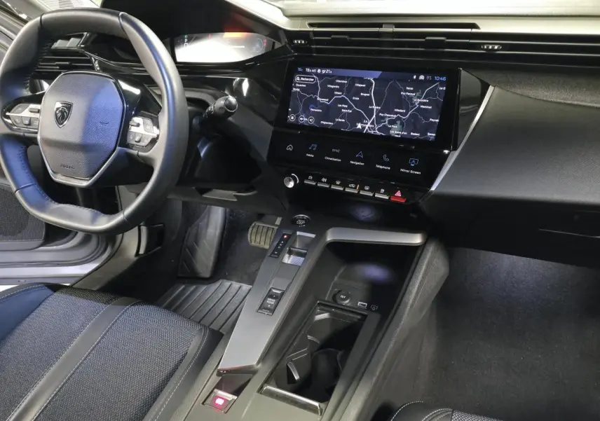 Intérieur Peugeot 408 2025 vu côté conducteur, volant cuir, écran tactile 10'' avec navigation et console centrale moderne.