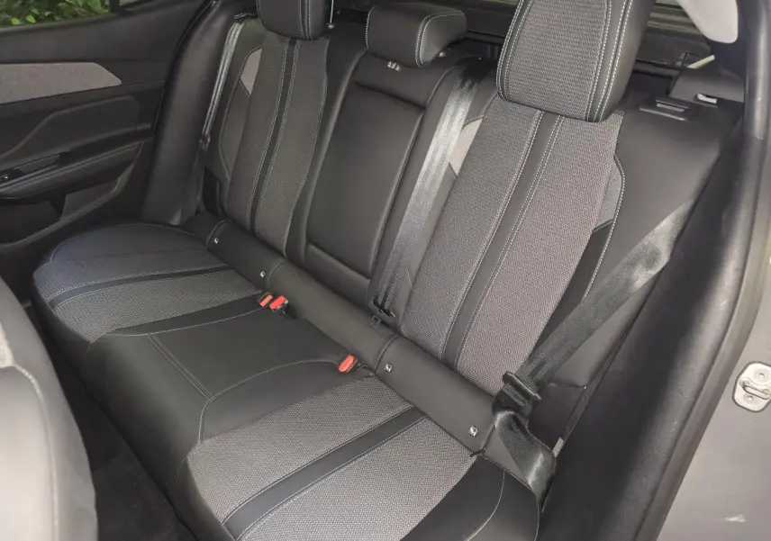 Vue latérale droite de la banquette arrière bi-matière gris et noir de la Peugeot 408 1.2i Hybrid Allure 2025.