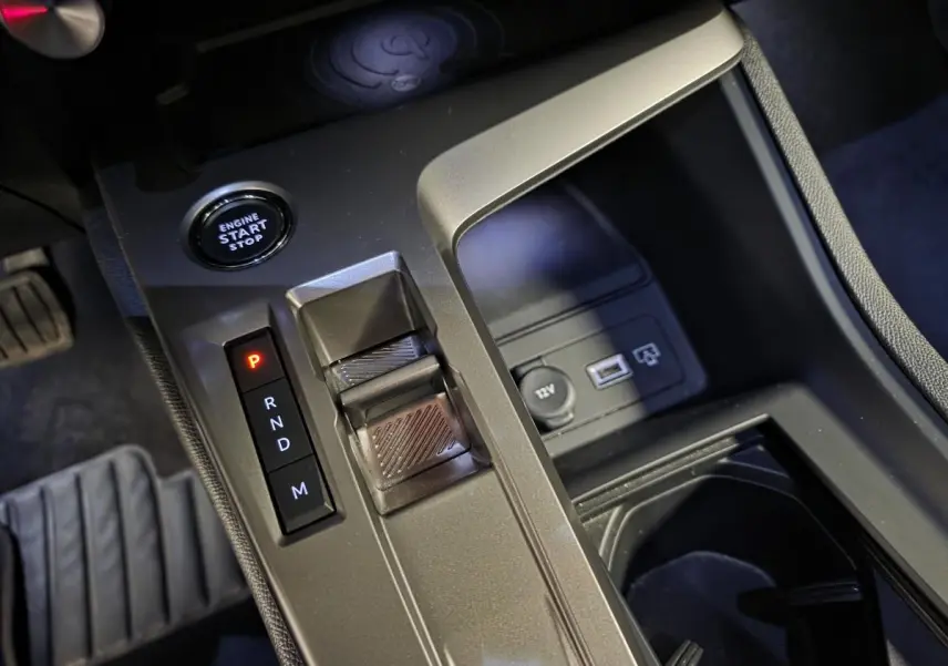 Gros plan sur la console centrale de la Peugeot 408 gris, montrant la commande de boîte auto et bouton start/stop.