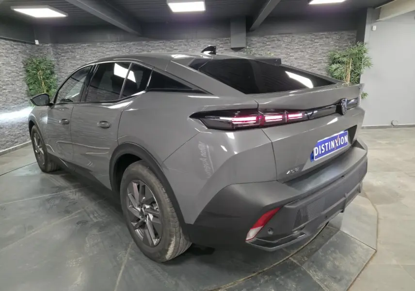 Vue 3/4 arrière droite d'une Peugeot 408 gris métallisé avec feux arrière LED et jantes alliage 17 pouces.