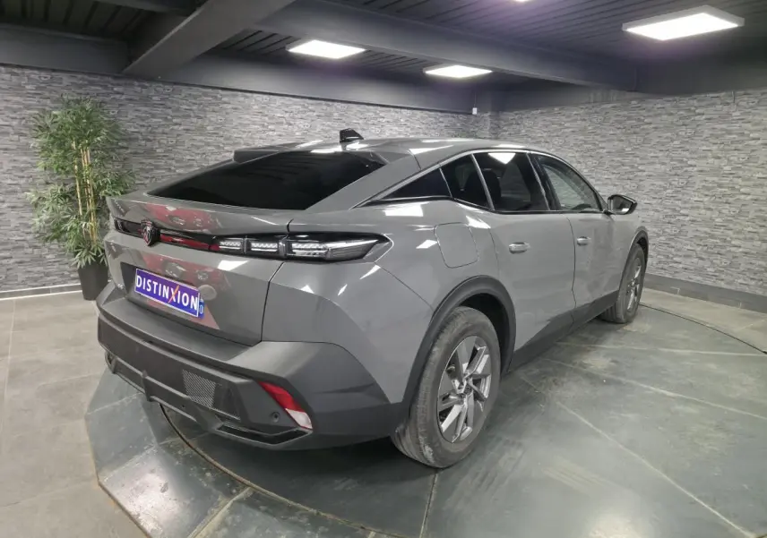 Vue 3/4 arrière droite d'une Peugeot 408 gris métallisé avec feux arrière LED et jantes alliage 17 pouces.