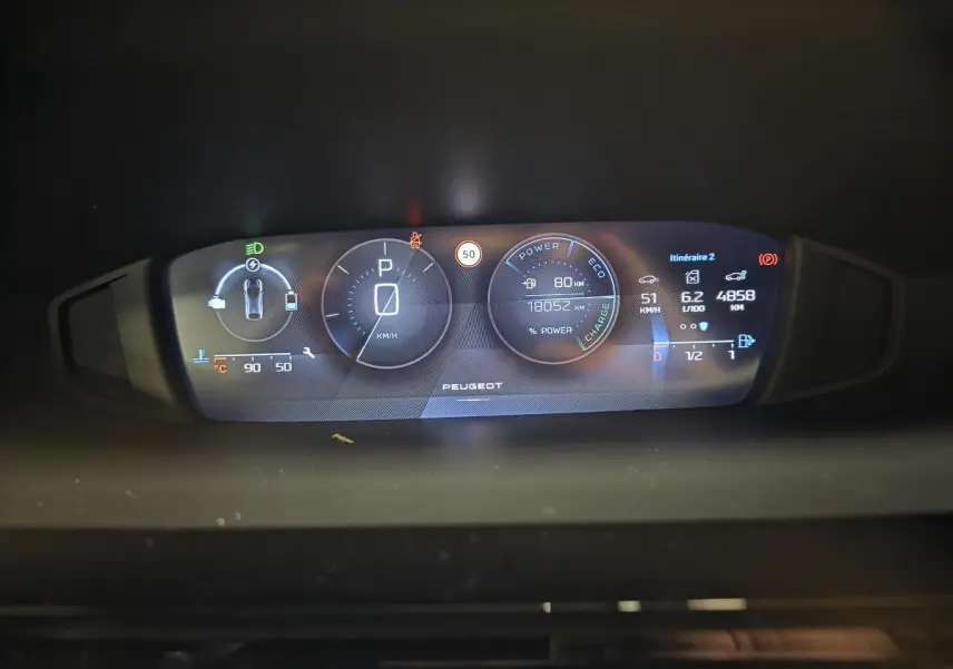 Combiné d'instrumentation numérique 10'' du Peugeot 408 hybride, affichant vitesse, autonomie et consommation.