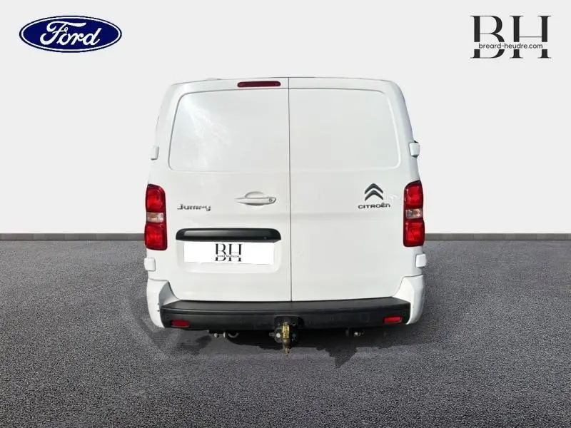 Vue arrière d'un Citroën Jumpy blanc Banquise avec portes battantes et attelage visible.