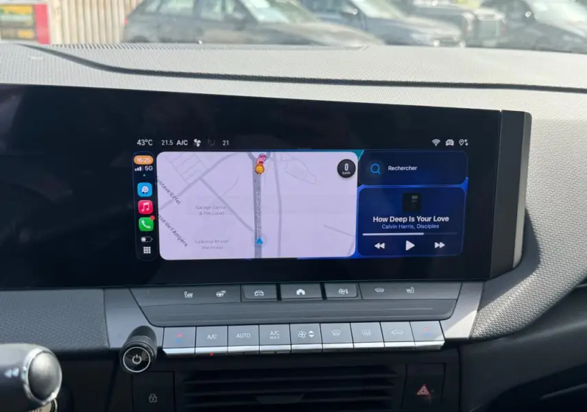 Vue rapprochée du tableau de bord de l'Opel Astra 2024, écran tactile affichant navigation et musique.