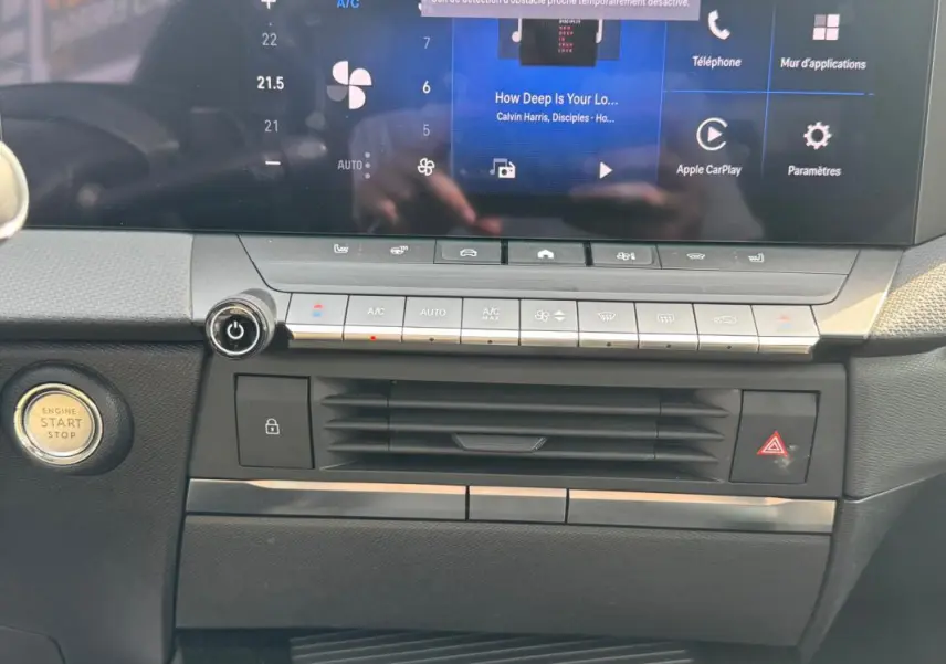 Vue rapprochée du tableau de bord de l'Opel Astra 2024, montrant l'écran tactile et les commandes de climatisation.
