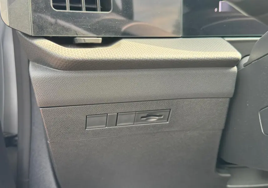 Détail intérieur montrant le bouton d'ouverture du capot sur la planche de bord côté conducteur de l’Opel Astra gris 2024.